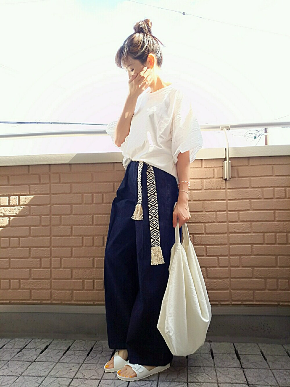 ホワイト系のサンダル、ブルー系のデニムパンツ、ホワイト系のTシャツ/カットソーを着用したレディースの夏コーディネートの1枚目の写真