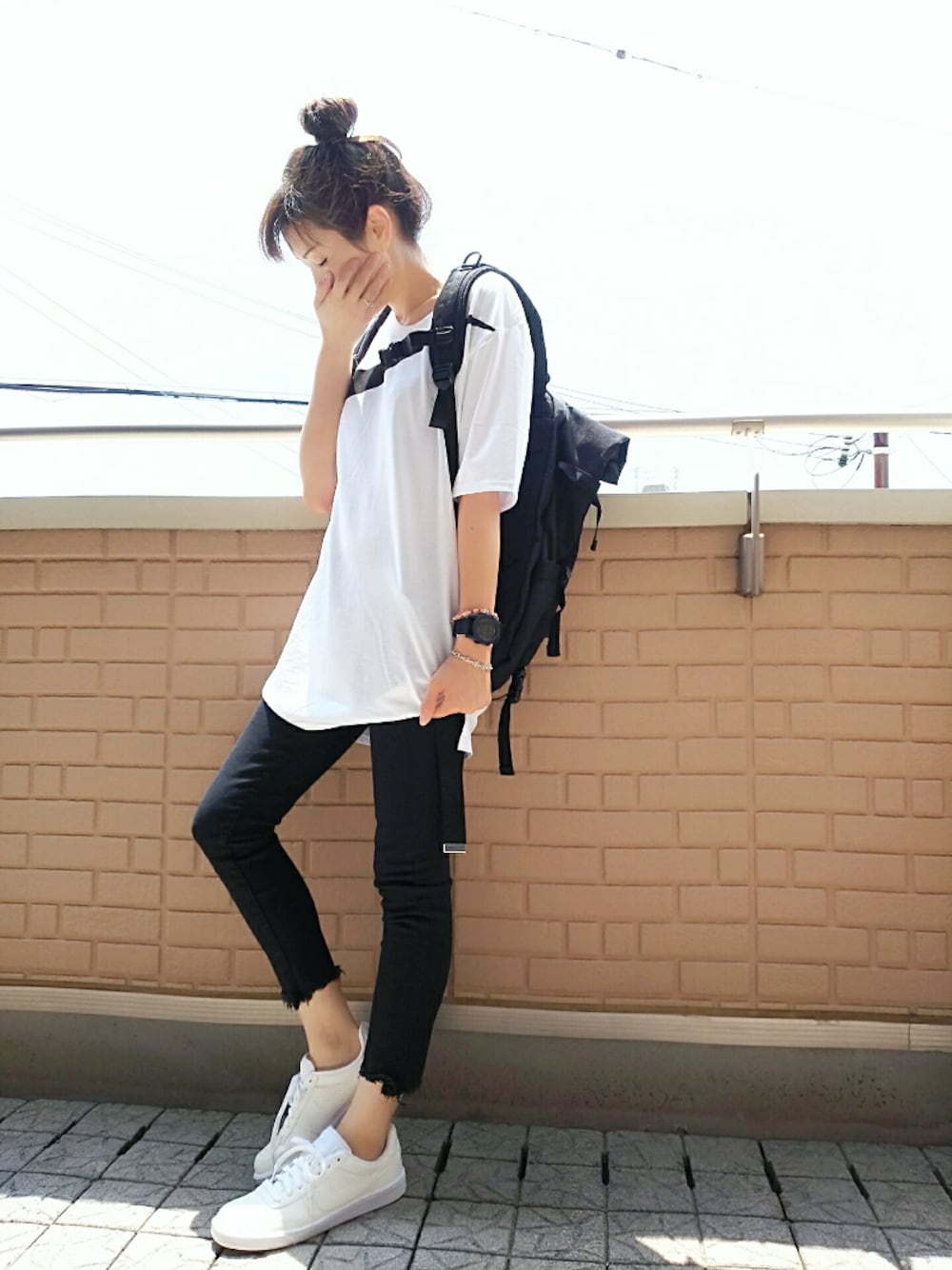 ホワイト系のTシャツ/カットソー、ブラック系のバックパック/リュック、ホワイト系のスニーカーを着用したレディースの夏コーディネートの1枚目の写真