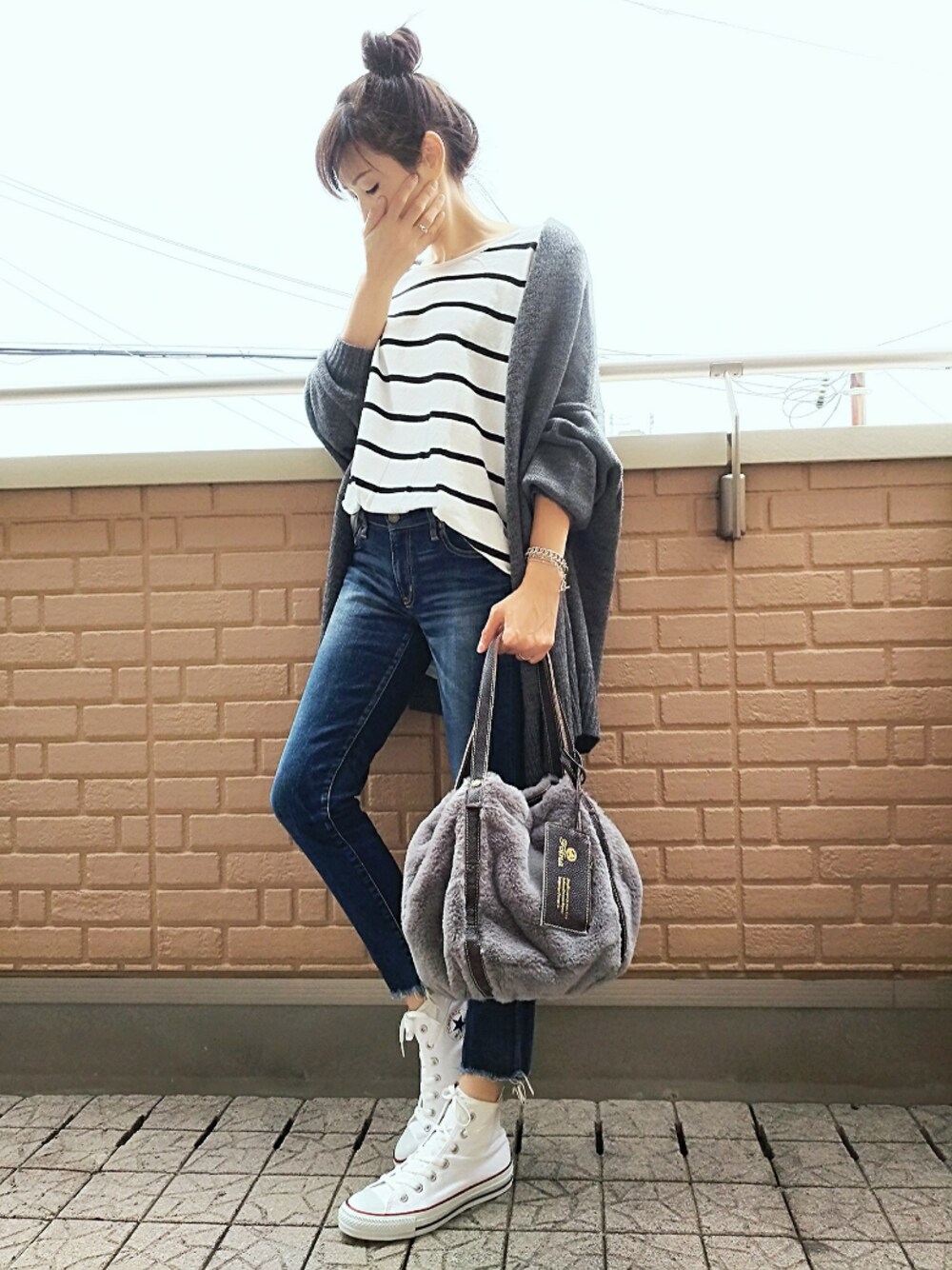 ホワイト系のスニーカー、グレー系のショルダーバッグ、グレー系のカーディガン/ボレロを着用したレディースの秋コーディネートの1枚目の写真