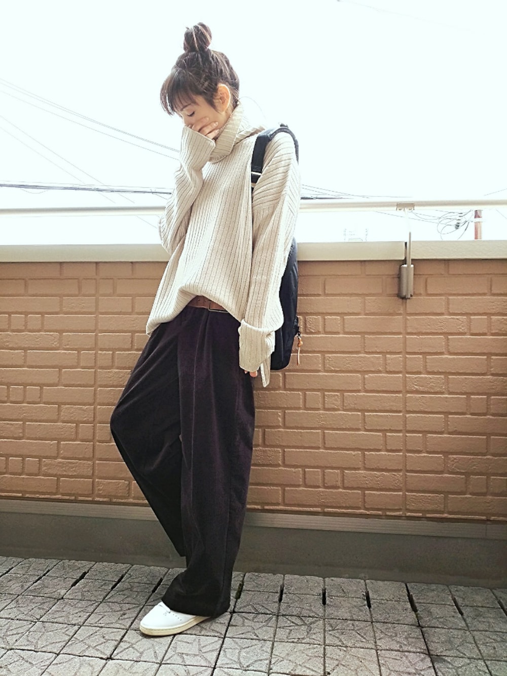 ホワイト系のスニーカー、グレー系のニット/セーター、ブラック系のその他パンツを着用したレディースの秋コーディネートの1枚目の写真