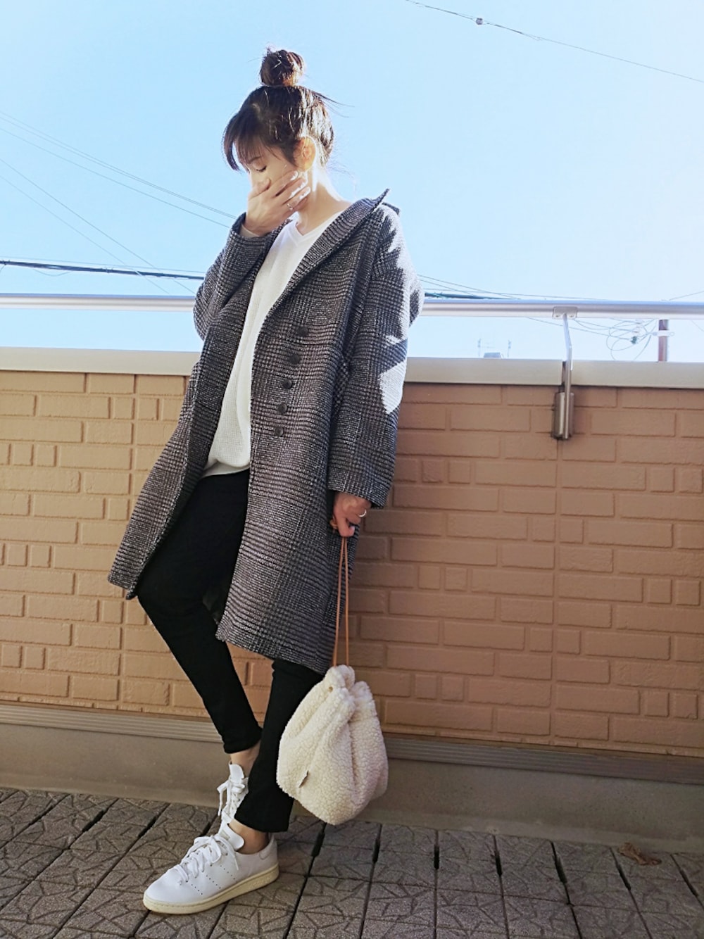 ブラック系のデニムパンツ、ホワイト系のショルダーバッグ、ブラック系のチェスターコートを着用したレディースの冬コーディネートの1枚目の写真