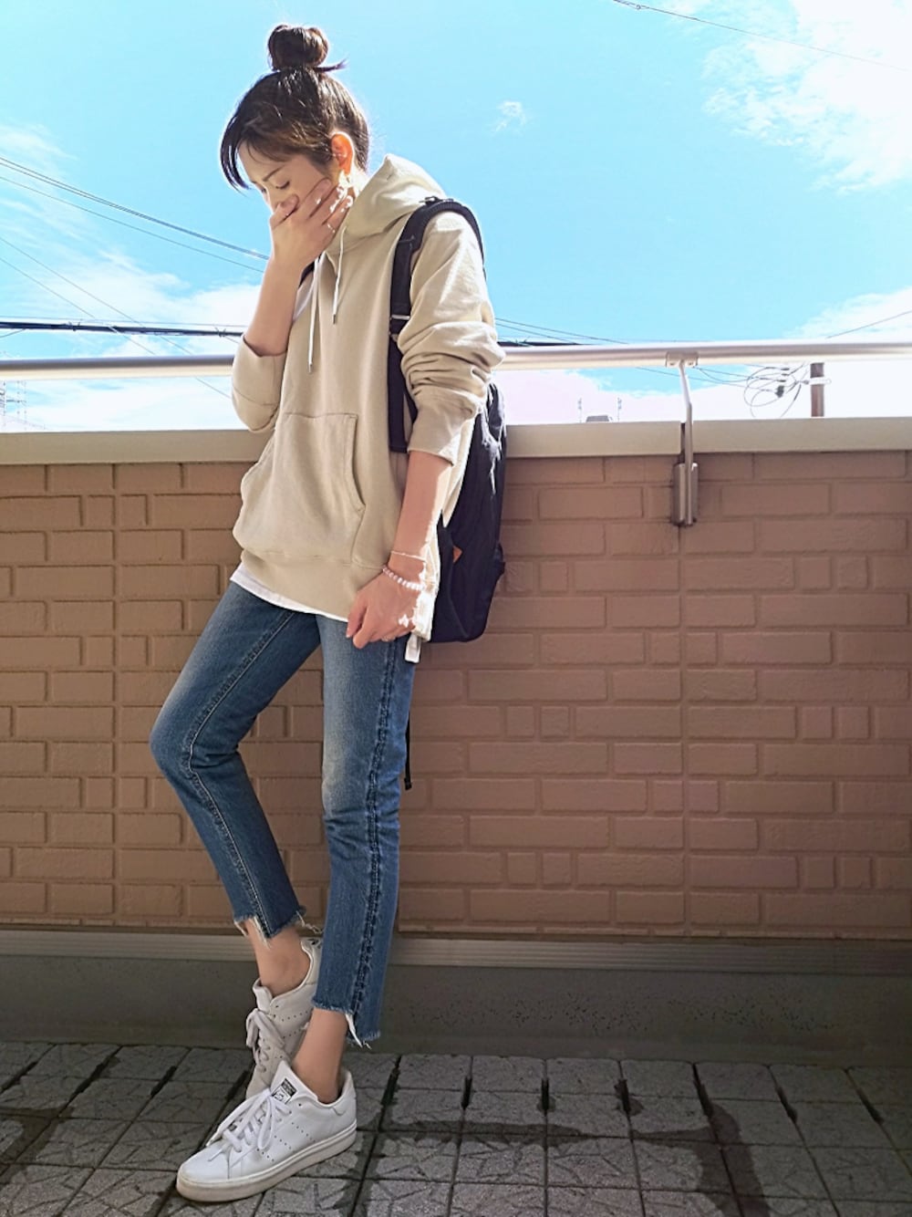 ホワイト系のスニーカー、ホワイト系のTシャツ/カットソー、ブラック系のバックパック/リュックを着用したレディースの春コーディネートの1枚目の写真