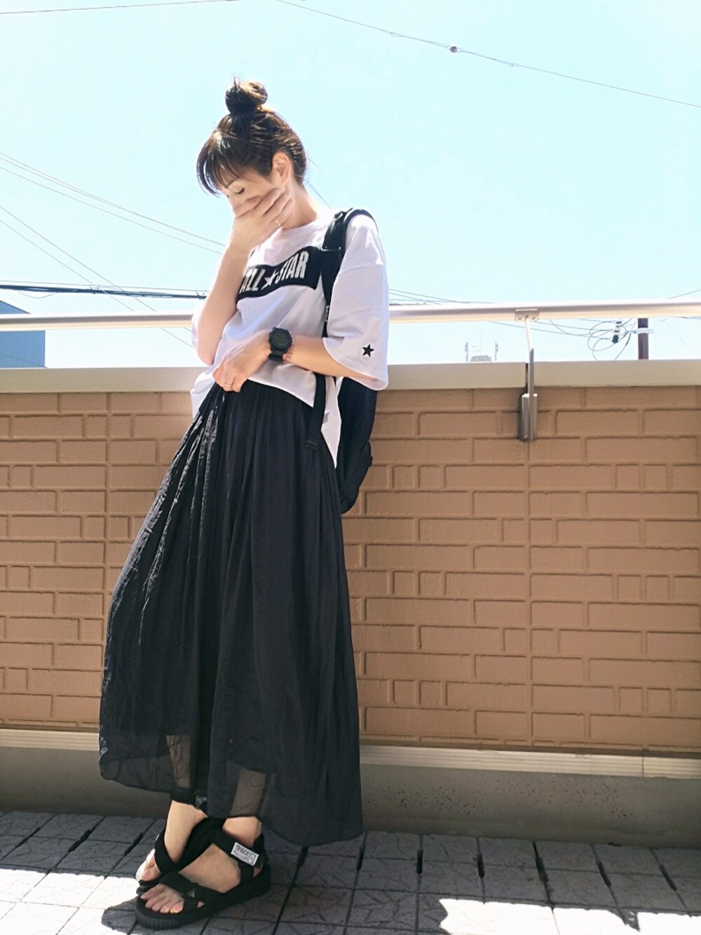 ブラック系のサンダル、ホワイト系のTシャツ/カットソー、ブラック系のバックパック/リュックを着用したレディースの夏コーディネートの1枚目の写真