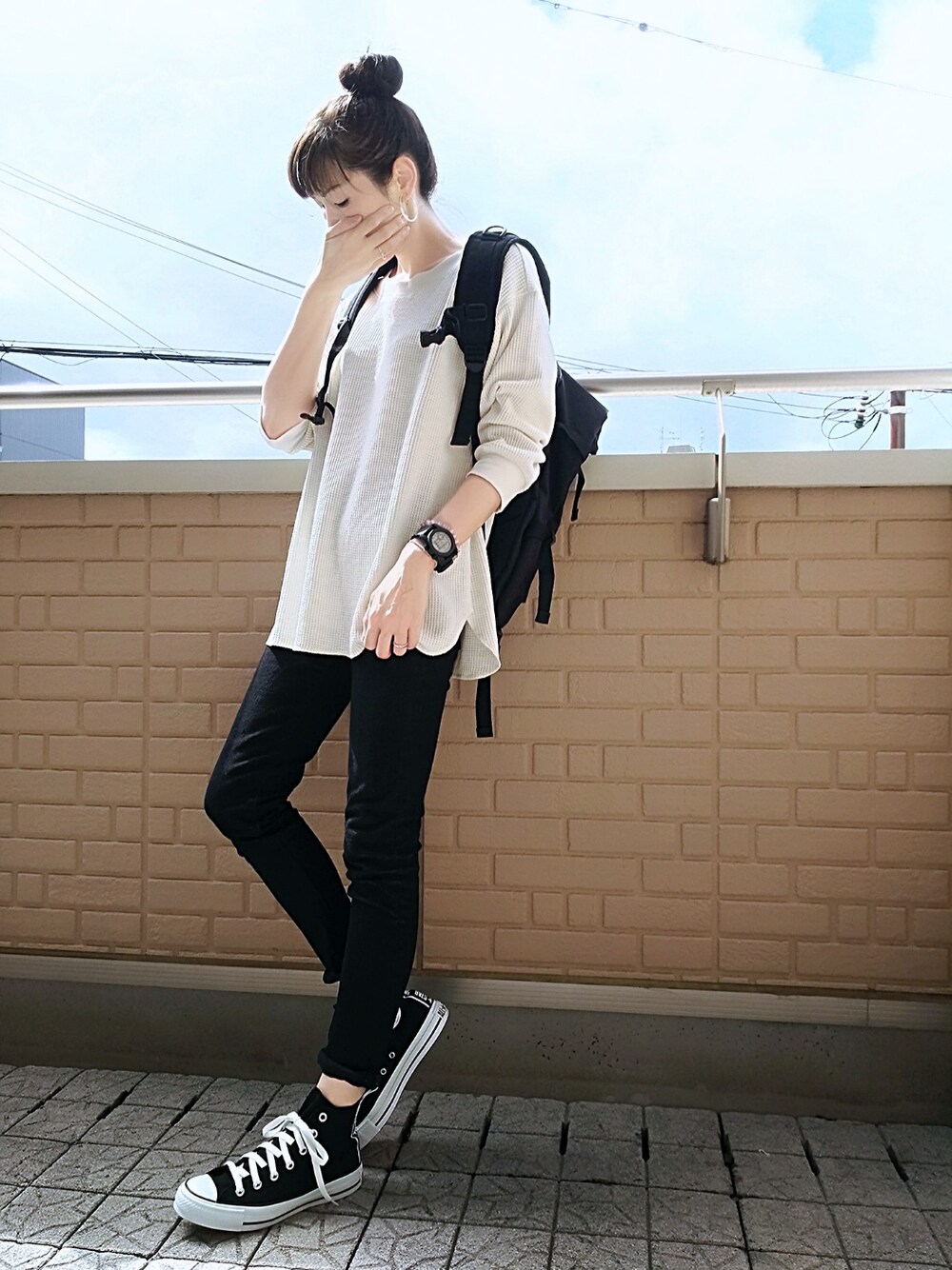 ホワイト系のTシャツ/カットソー、ブラック系のスニーカー、ブラック系のデニムパンツを着用したレディースの秋コーディネートの1枚目の写真