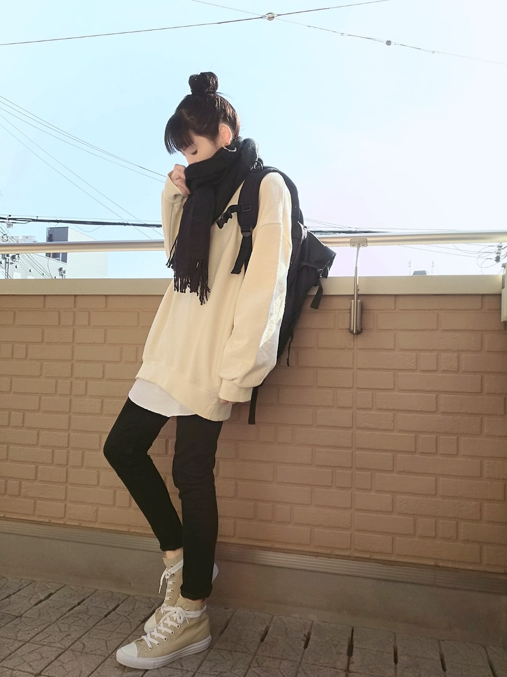 ブラック系のバックパック/リュック、ホワイト系のスウェット、ブラック系のデニムパンツを着用したレディースの冬コーディネートの1枚目の写真