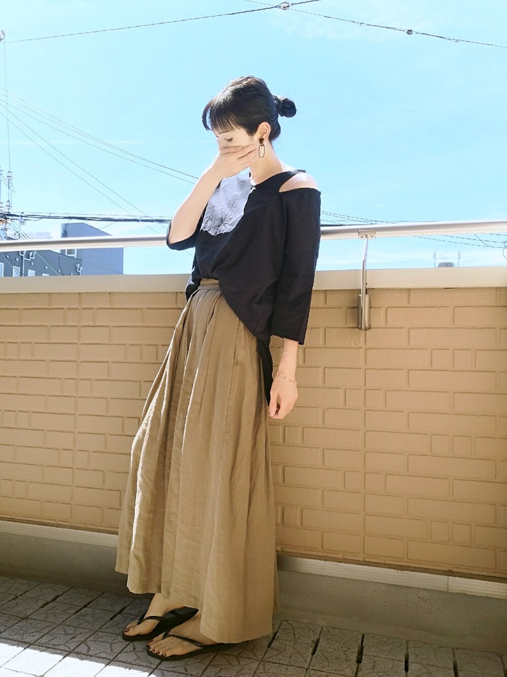 ブラック系のTシャツ/カットソー、ベージュ系のスカート、ブラック系のサンダルを着用したレディースの夏コーディネートの1枚目の写真