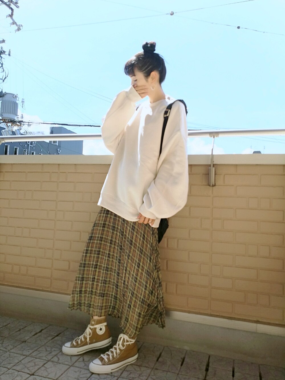 ベージュ系のスウェット、ブラウン系のスカート、ブラウン系のスニーカーを着用したレディースの秋コーディネートの1枚目の写真