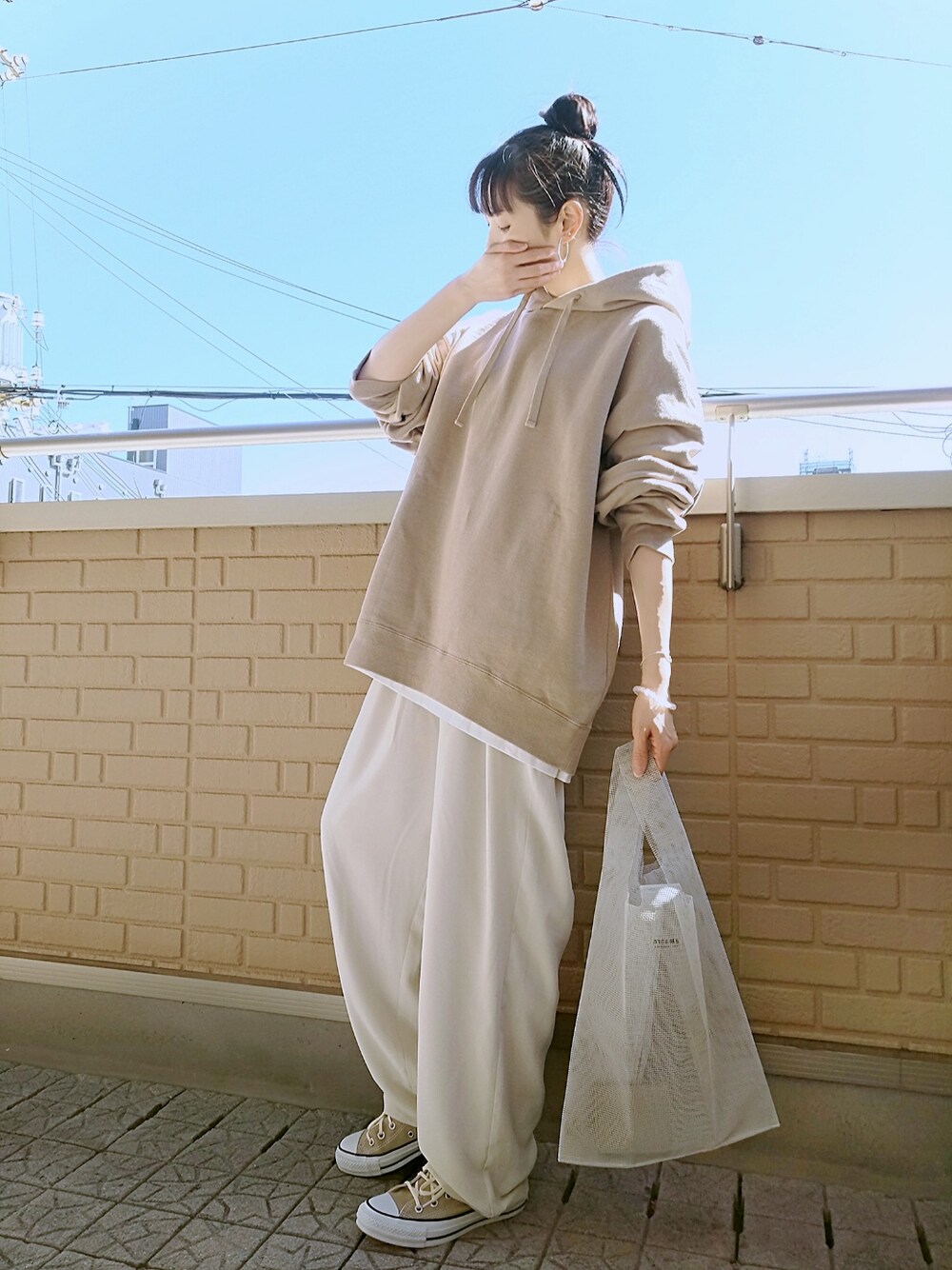 ベージュ系のその他パンツ、ホワイト系のエコバッグ/サブバッグ、ベージュ系のスニーカーを着用したレディースの春コーディネートの1枚目の写真
