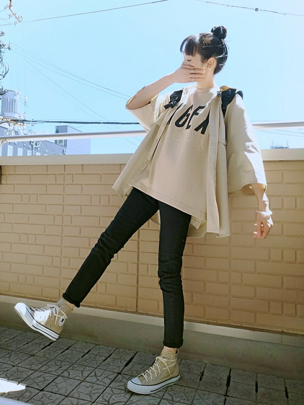 ベージュ系のTシャツ/カットソー、ベージュ系のスニーカー、ブラック系のバックパック/リュックを着用したレディースの春コーディネートの1枚目の写真