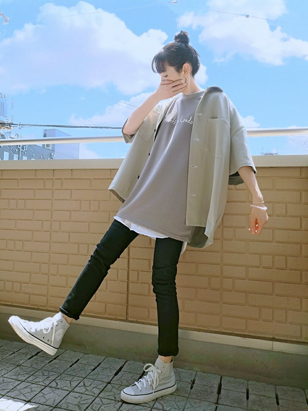 グリーン系のシャツ/ブラウス、グレー系のTシャツ/カットソー、ブラック系のデニムパンツを着用したレディースの春コーディネートの1枚目の写真