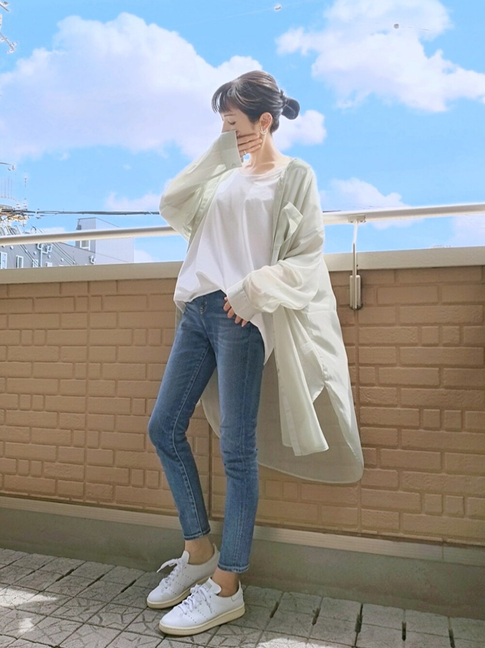 グリーン系のシャツ/ブラウス、ブルー系のデニムパンツ、ホワイト系のスニーカーを着用したレディースの春コーディネートの1枚目の写真