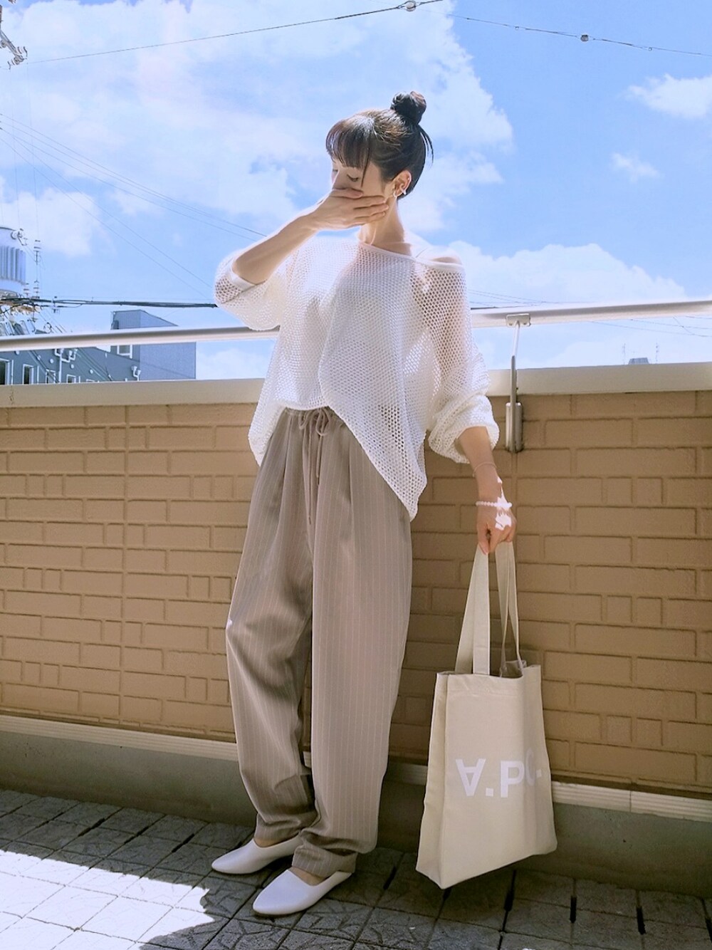 ホワイト系のキャミソール、ホワイト系のトップス、ベージュ系のトートバッグを着用したレディースの夏コーディネートの1枚目の写真