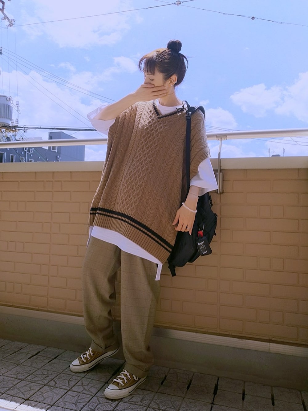 ホワイト系のTシャツ/カットソー、ベージュ系のニット/セーター、ブラック系のトートバッグを着用したレディースの秋コーディネートの1枚目の写真