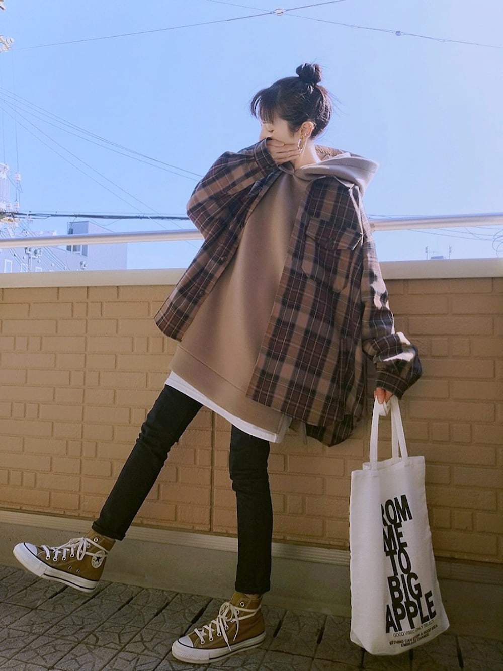 ブラック系のデニムパンツ、ブラウン系のスニーカー、ブラウン系のパーカーを着用したレディースの秋コーディネートの1枚目の写真