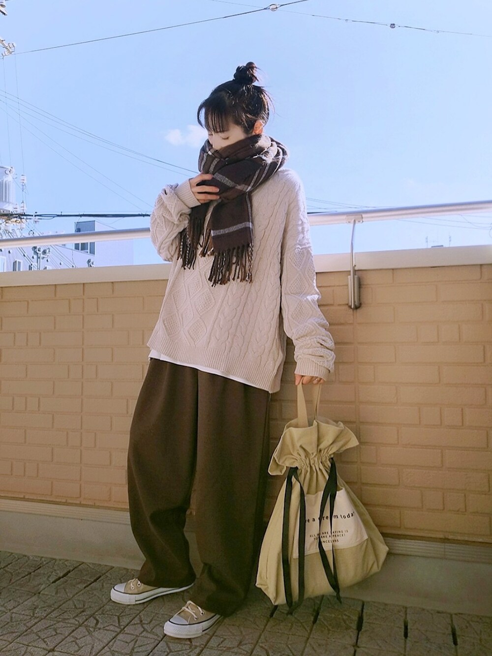 ベージュ系のニット/セーター、ブラウン系のその他パンツ、ベージュ系のトートバッグを着用したレディースの秋コーディネートの1枚目の写真