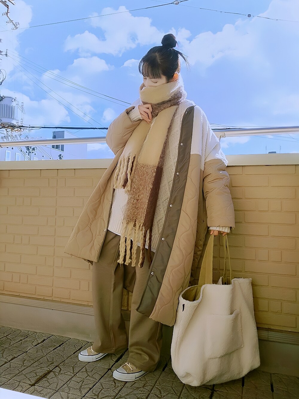 ベージュ系のニット/セーター、ベージュ系のダウンジャケット/コート、ベージュ系のトートバッグを着用したレディースの冬コーディネートの1枚目の写真