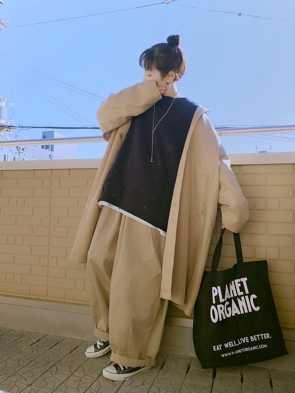 ブラック系のスウェット、ベージュ系のステンカラーコート、ベージュ系のパンツを着用したレディースの冬コーディネートの1枚目の写真