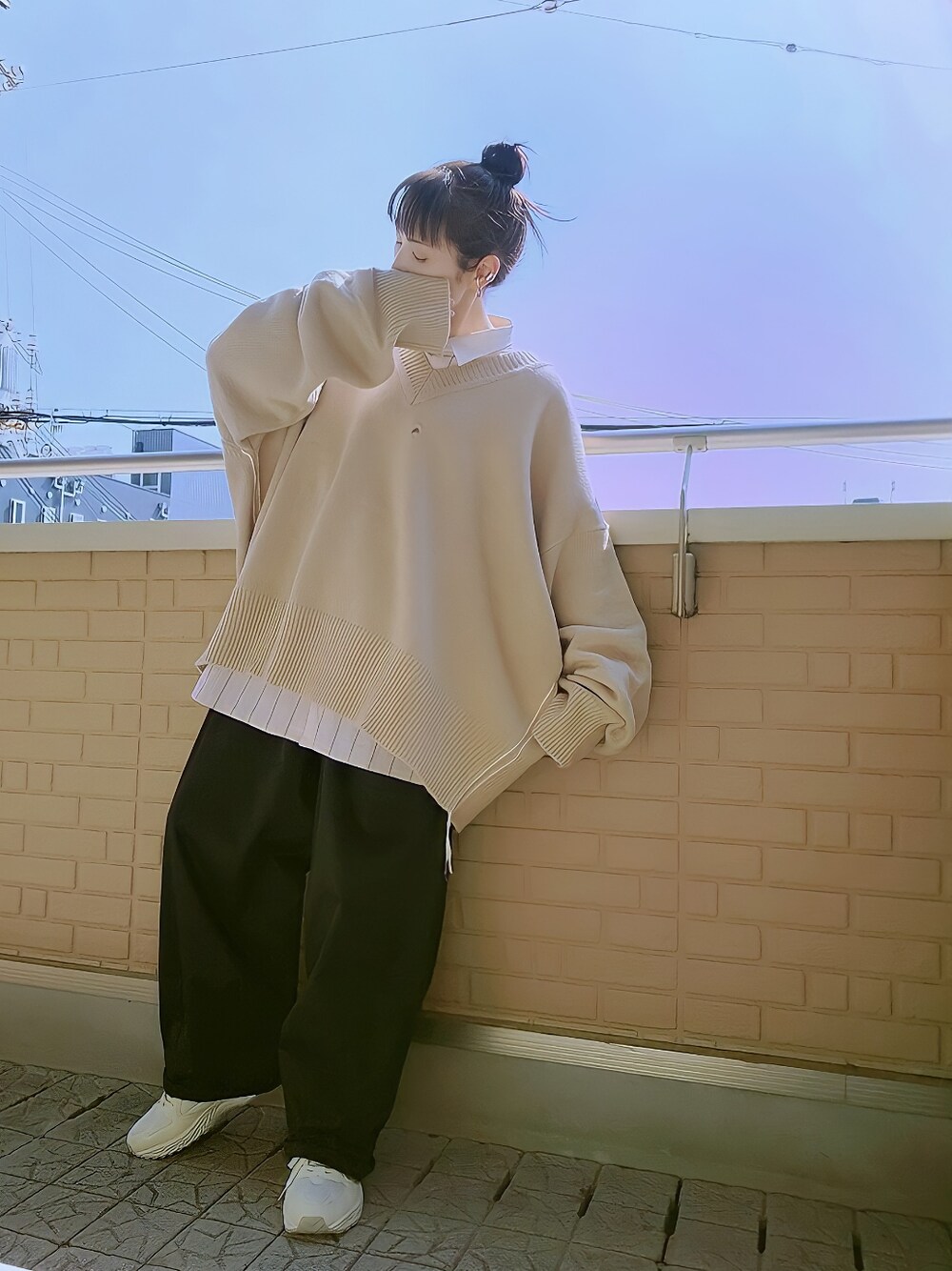 ベージュ系のシャツ/ブラウス、ベージュ系のニット/セーター、ベージュ系のスニーカーを着用したレディースの春コーディネートの1枚目の写真