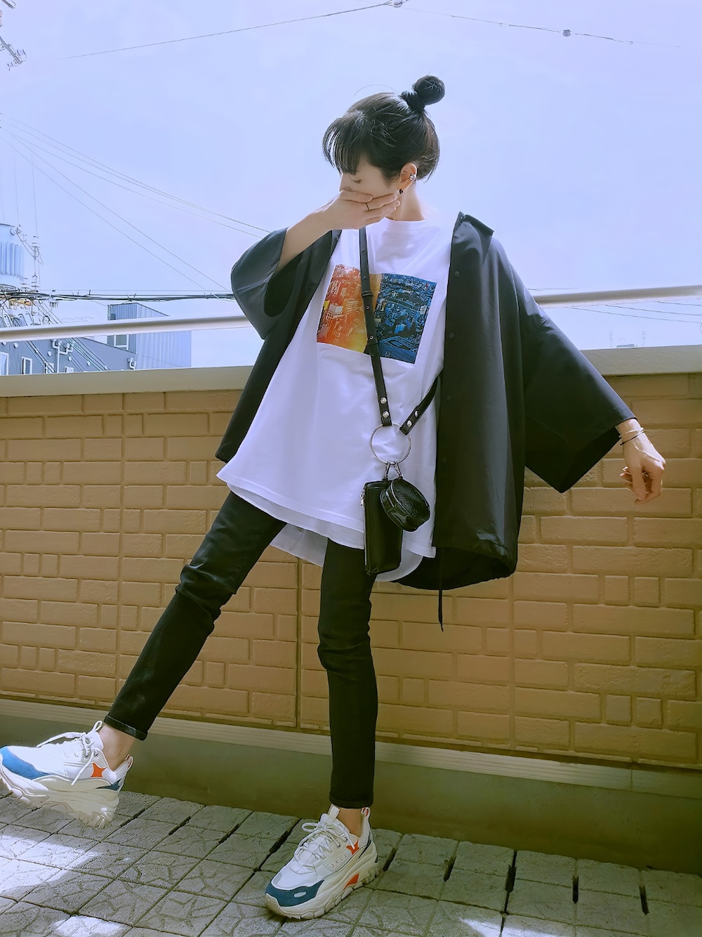 ブラック系のデニムパンツ、ホワイト系のスニーカー、ブラック系のジャケット/アウターを着用したレディースの春コーディネートの1枚目の写真