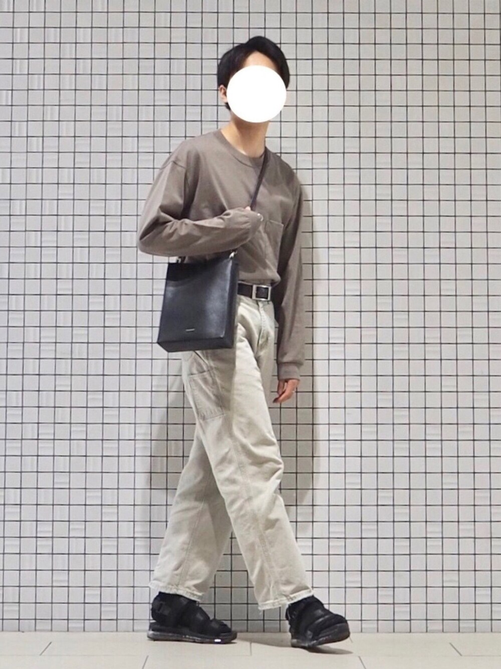 グレー系のTシャツ/カットソー、ホワイト系のパンツ、ブラック系のサンダルを着用したメンズの春コーディネートの1枚目の写真