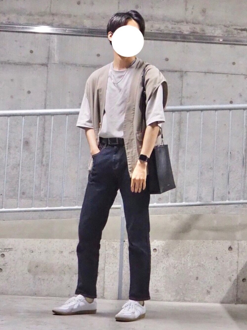 グレー系のベスト、ブラック系のショルダーバッグ、ブルー系のデニムパンツを着用したメンズの春コーディネートの1枚目の写真