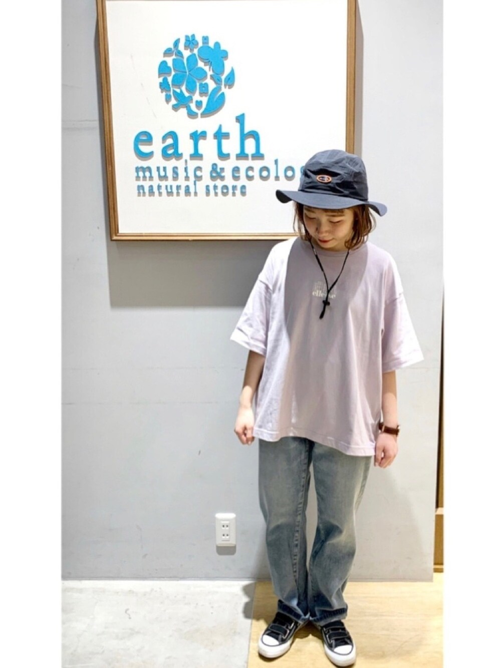 パープル系のTシャツ/カットソー、ブルー系のデニムパンツ、ブラック系のスニーカーを着用したレディースの春コーディネートの1枚目の写真