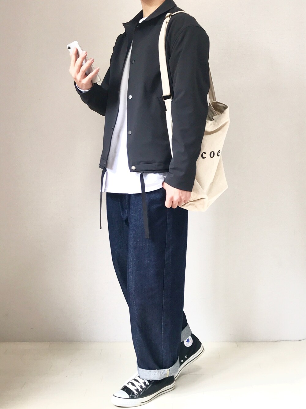 ホワイト系のTシャツ/カットソー、ホワイト系のトートバッグ、ブラック系のスニーカーを着用したメンズの春コーディネートの1枚目の写真
