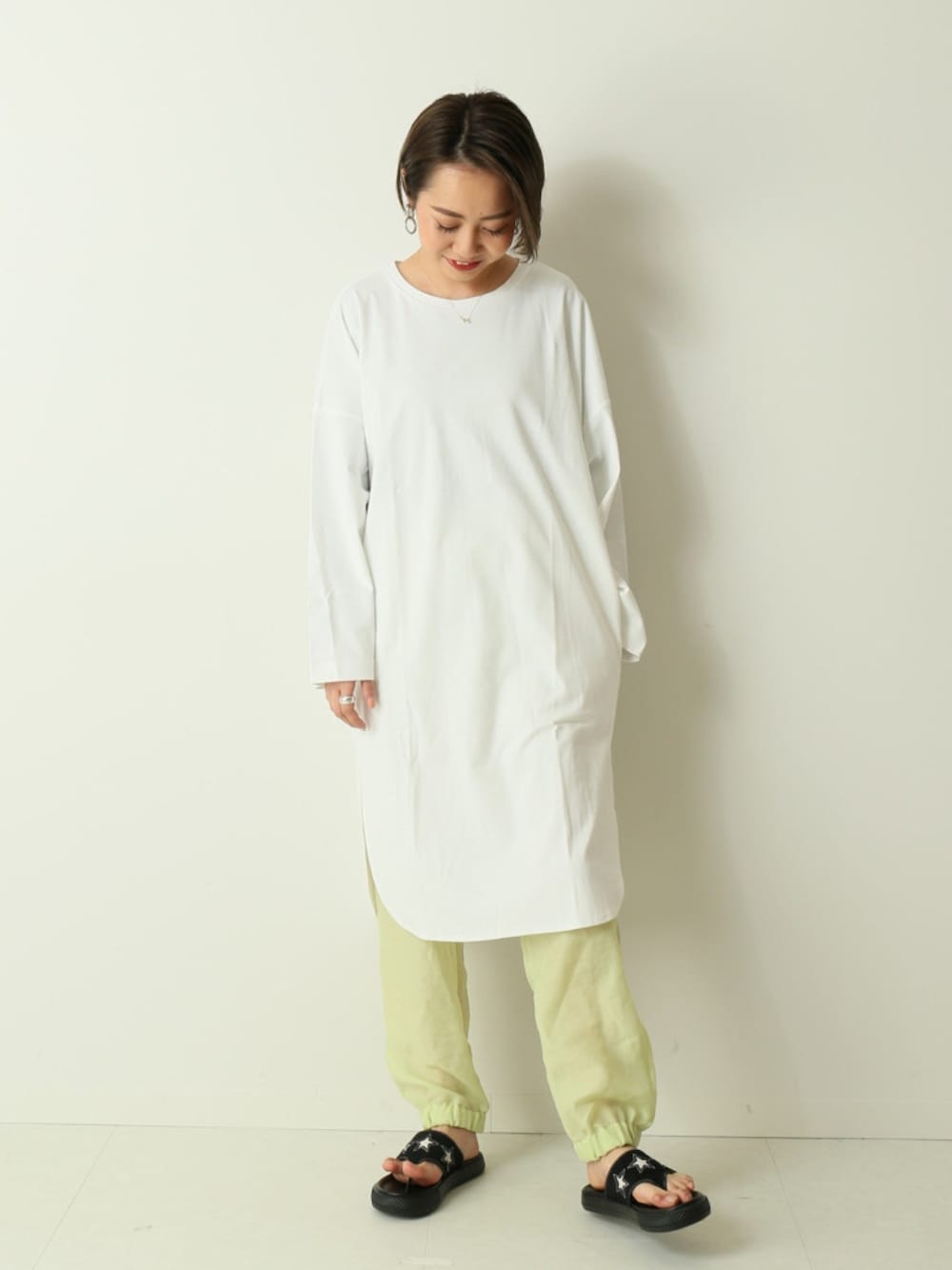 ホワイト系のワンピース、イエロー系のレギンス/スパッツを着用したレディースの春コーディネートの1枚目の写真