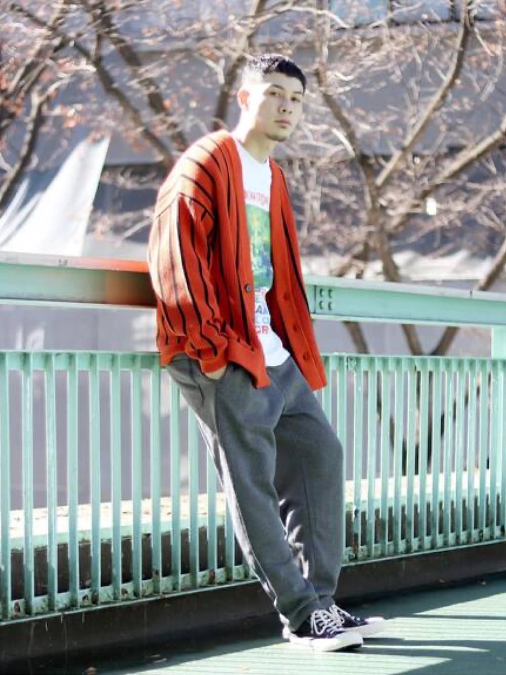 オレンジ系のカーディガン/ボレロ、ブラック系のスニーカーを着用したメンズの春コーディネートの1枚目の写真