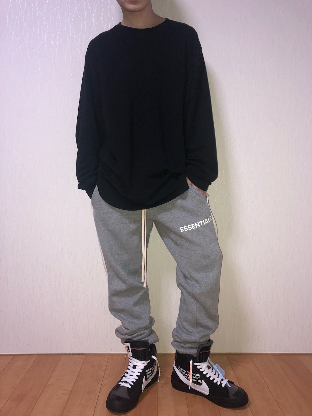 ブラック系のTシャツ/カットソー、グレー系のパンツ、ブラック系のスニーカーを着用したメンズの冬コーディネートの1枚目の写真