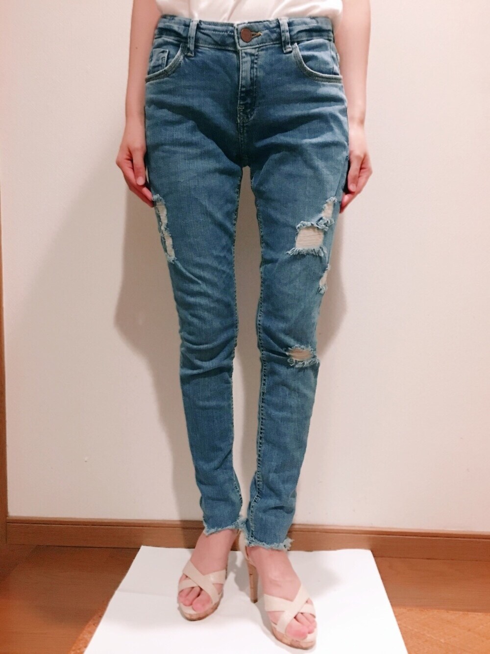 ブルー系のデニムパンツ、ベージュ系のサンダルを着用したレディースの夏コーディネートの1枚目の写真