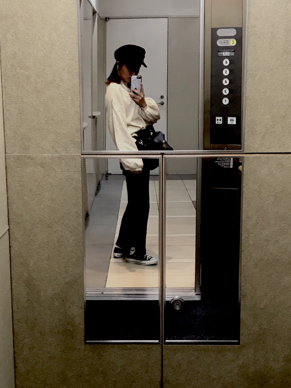 ブラック系のその他パンツ、ホワイト系のニット/セーター、ブラック系のショルダーバッグを着用したレディースの秋コーディネートの1枚目の写真