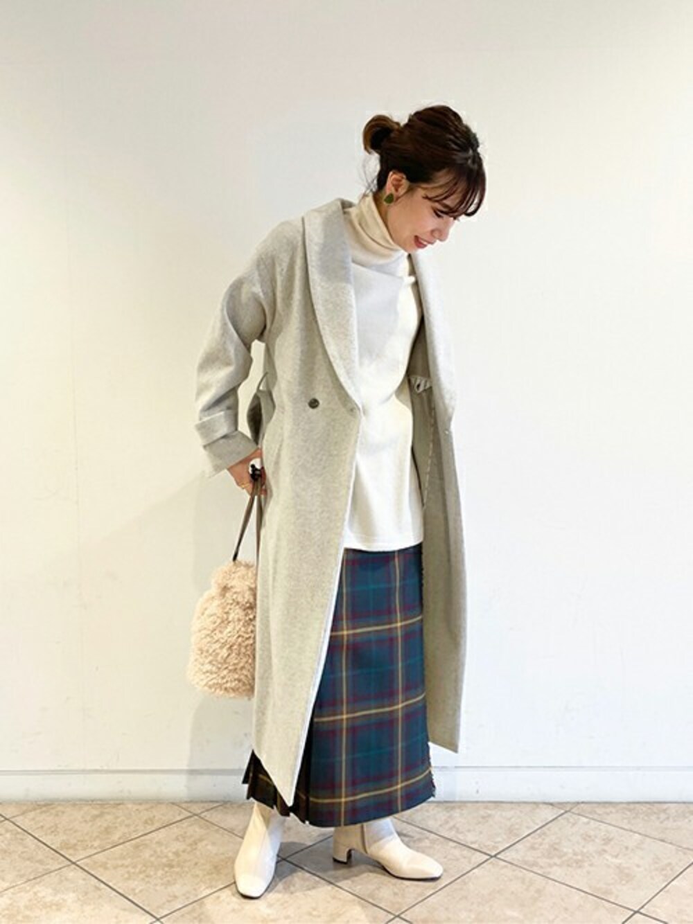 グレー系のその他アウター、ホワイト系のニット/セーター、イエロー系のスカートを着用したレディースの冬コーディネートの1枚目の写真