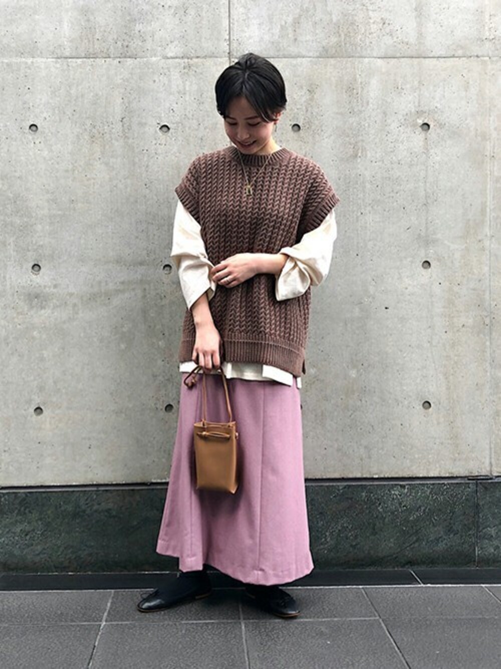 ブラウン系のニット/セーター、ホワイト系のTシャツ/カットソー、ピンク系のスカートを着用したレディースの冬コーディネートの1枚目の写真