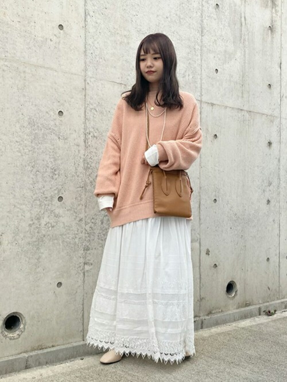 ピンク系のカーディガン/ボレロ、ホワイト系のTシャツ/カットソー、ホワイト系のスカートを着用したレディースの冬コーディネートの1枚目の写真