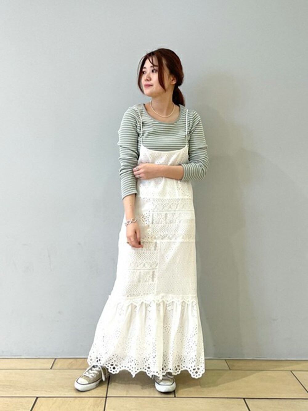 ホワイト系のワンピース、グリーン系のTシャツ/カットソー、ベージュ系のスニーカーを着用したレディースの冬コーディネートの1枚目の写真