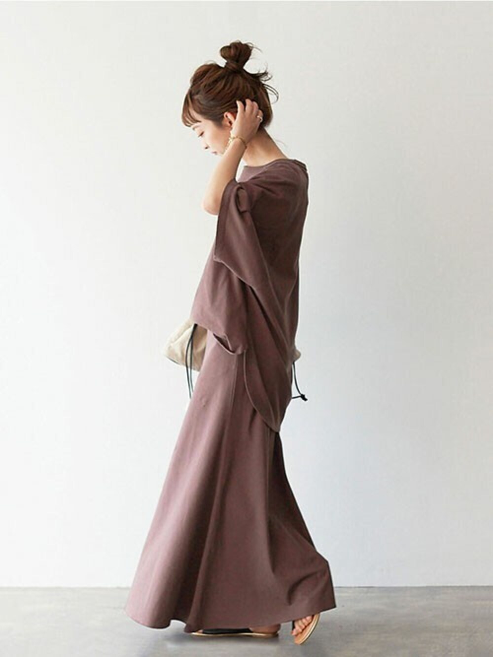 ブラウン系のTシャツ/カットソー、ブラウン系のスカート、ブラック系のハンドバッグを着用したレディースの夏コーディネートの1枚目の写真