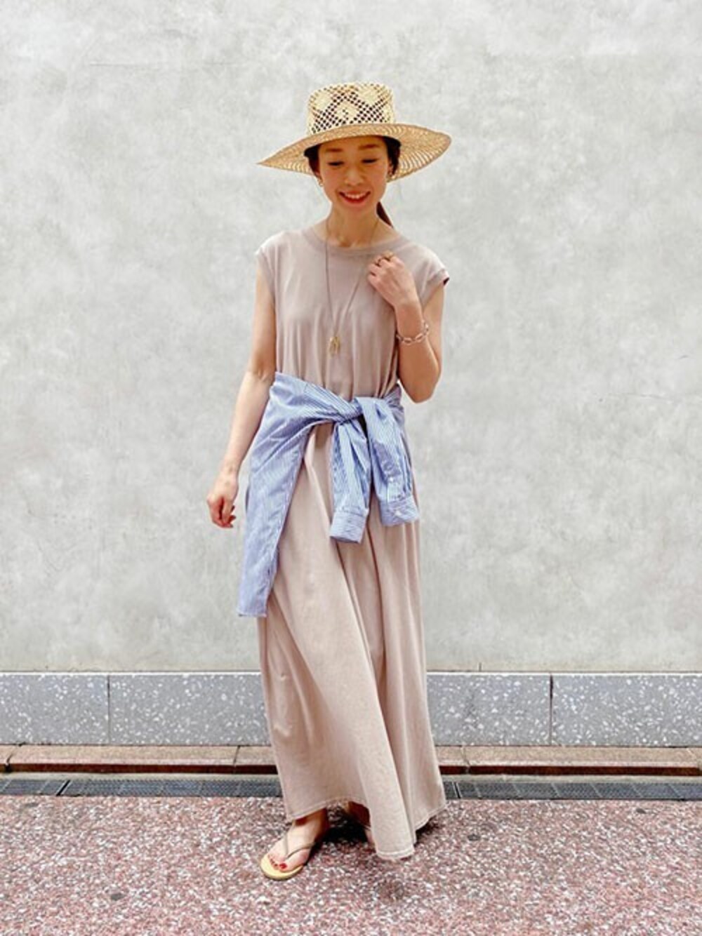 ベージュ系のワンピース、ブルー系のシャツ/ブラウス、ゴールド系のサンダルを着用したレディースの夏コーディネートの1枚目の写真