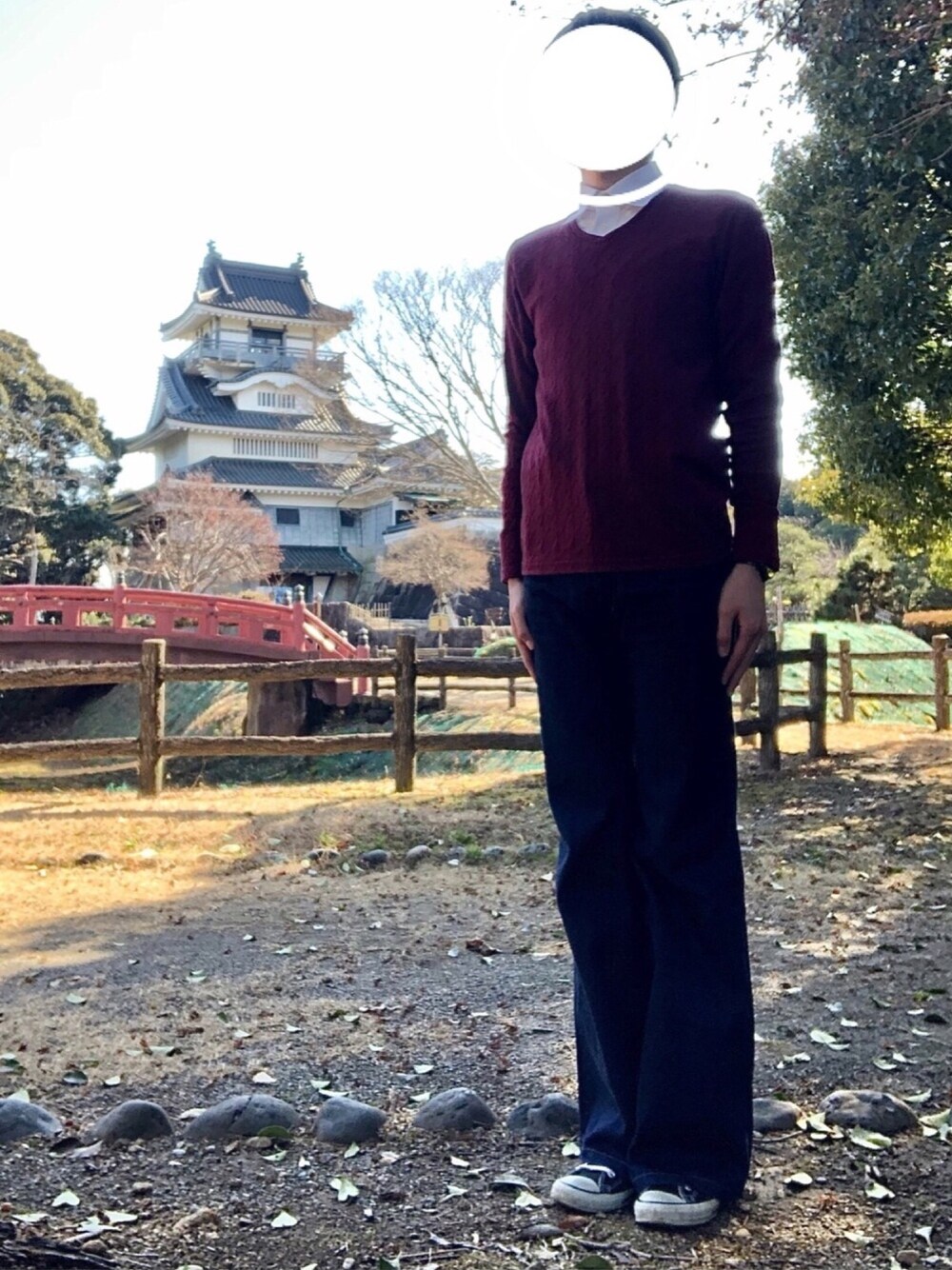 ブルー系のデニムパンツ、レッド系のニット/セーター、ホワイト系のシャツ/ブラウスを着用したメンズの冬コーディネートの1枚目の写真