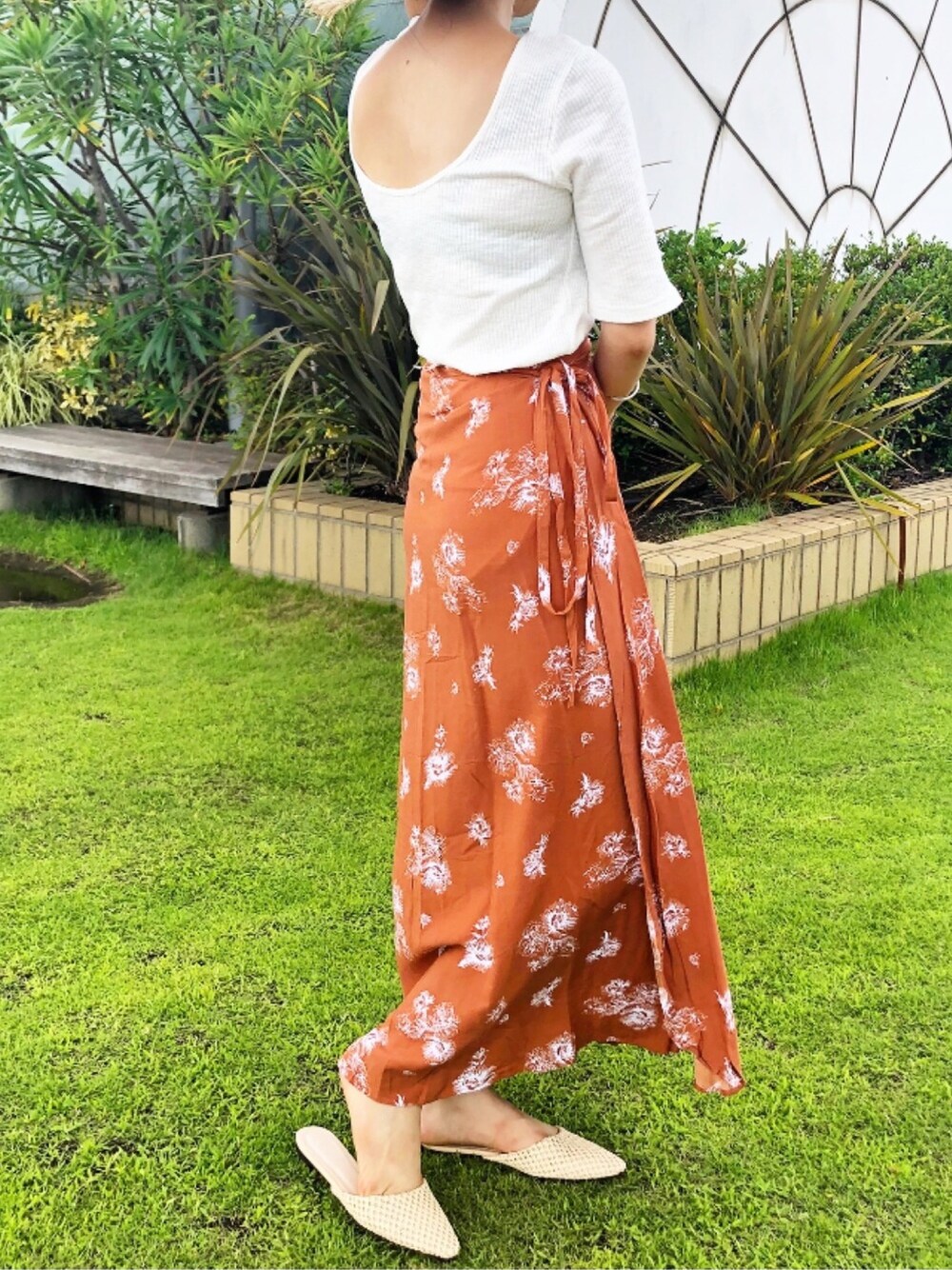 オレンジ系のスカート、ベージュ系のサンダル、ホワイト系のTシャツ/カットソーを着用したレディースの夏コーディネートの1枚目の写真