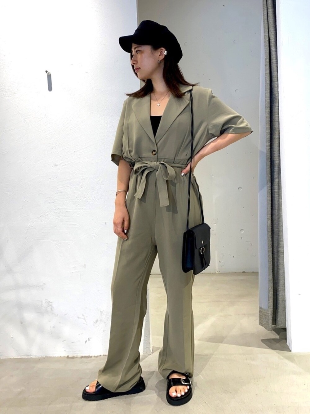 グリーン系のサロペット/オーバーオール、ブラック系のサンダル、ブラック系のキャスケットを着用したレディースの夏コーディネートの1枚目の写真