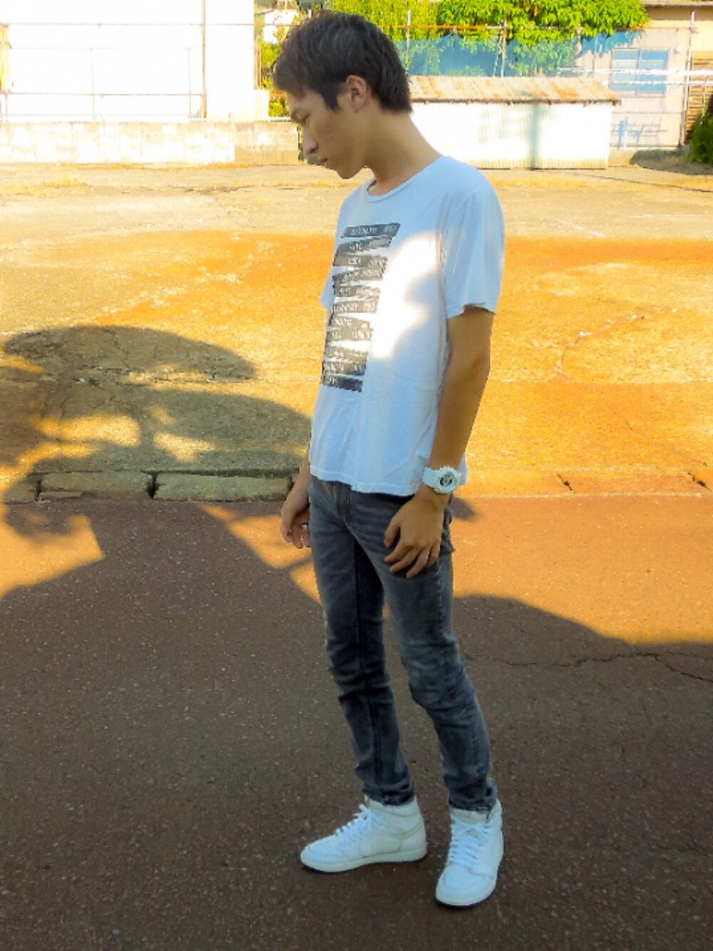 ブラック系のデニムパンツ、ホワイト系のスニーカー、ホワイト系のTシャツ/カットソーを着用したメンズの夏コーディネートの1枚目の写真