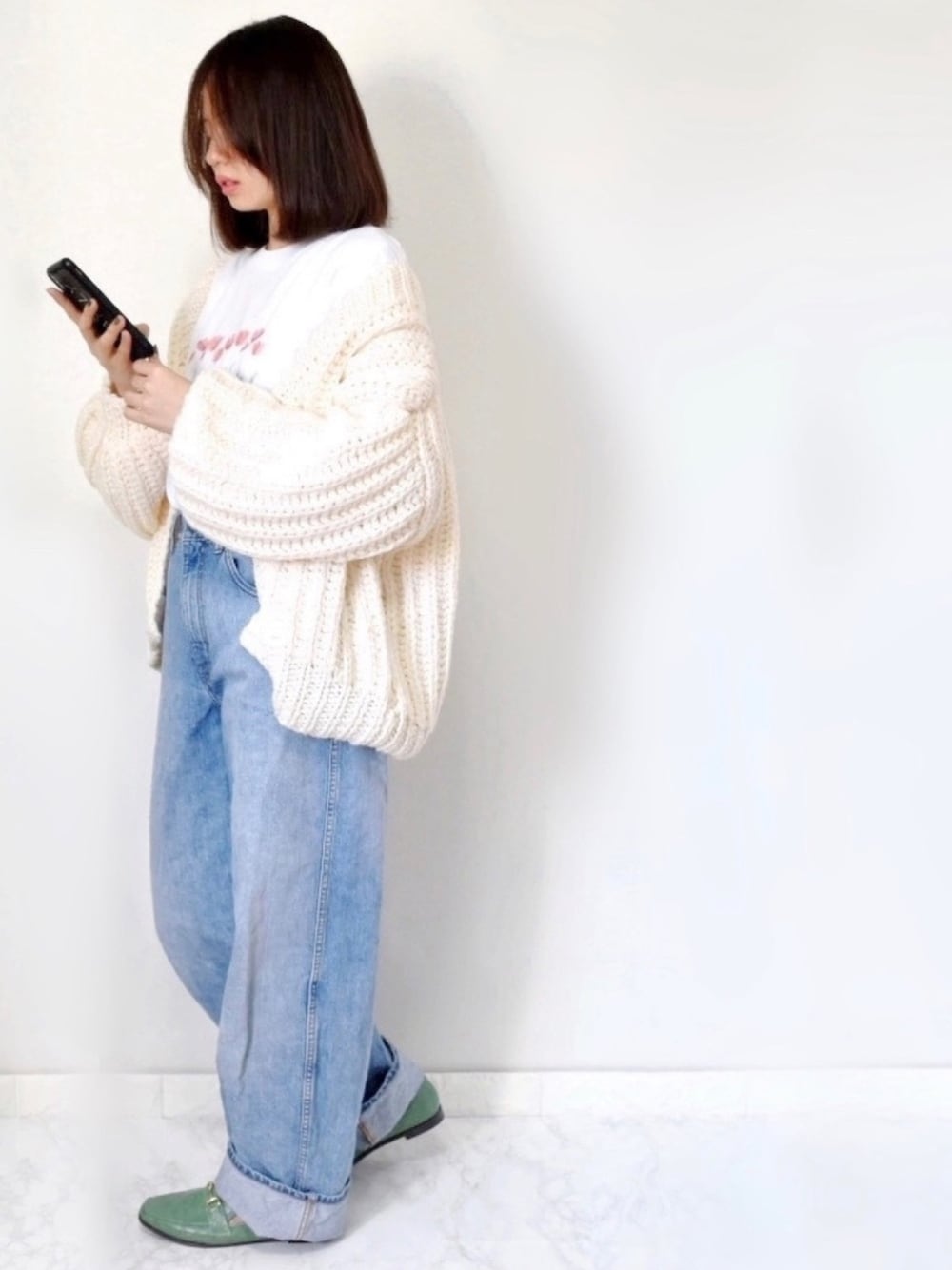 ホワイト系のカーディガン/ボレロ、ブルー系のデニムパンツ、その他のローファーを着用したレディースの春コーディネートの1枚目の写真