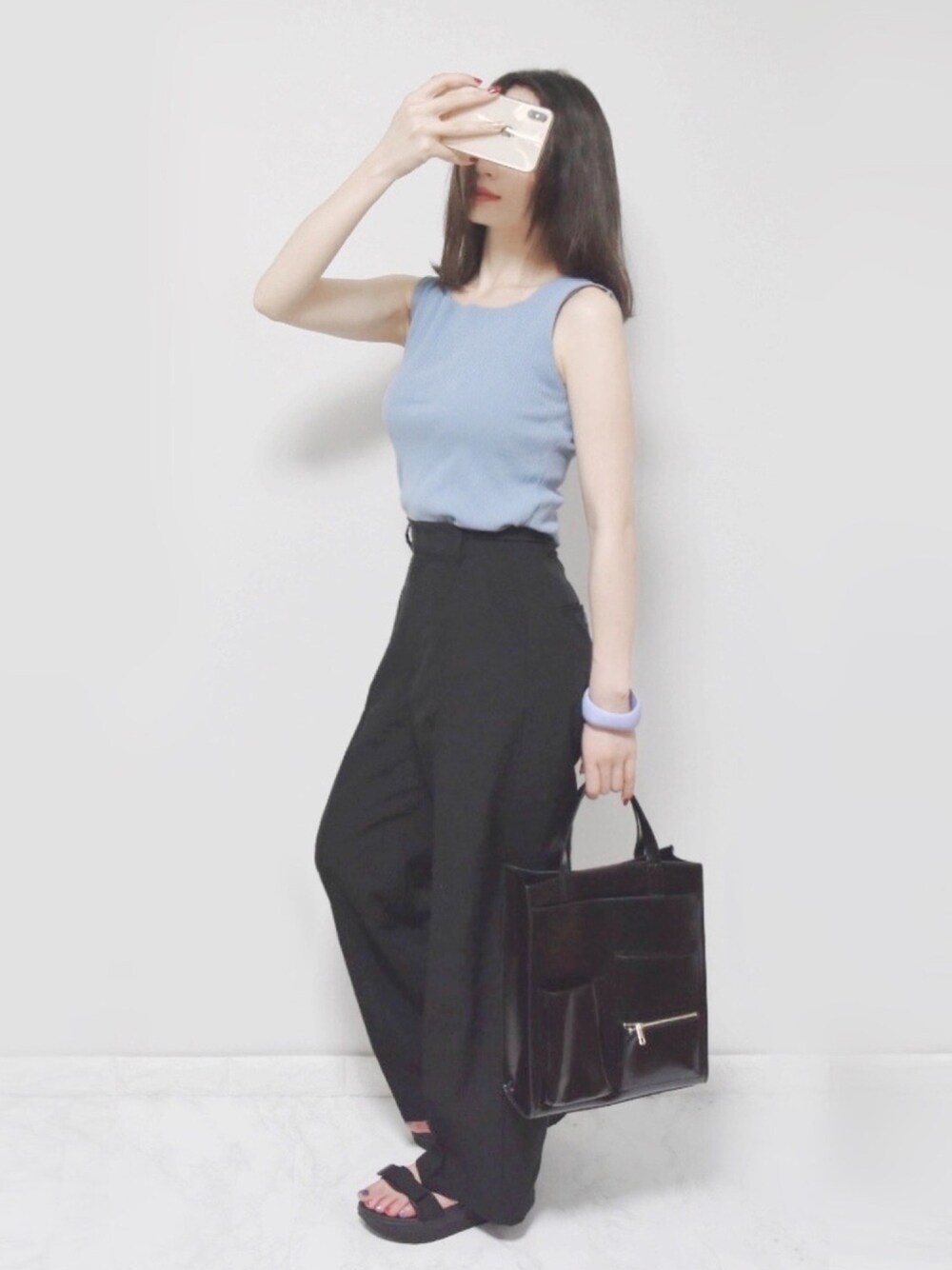 ブルー系のトップス、ブラック系のショルダーバッグ、ブラック系のスラックスを着用したレディースの夏コーディネートの1枚目の写真
