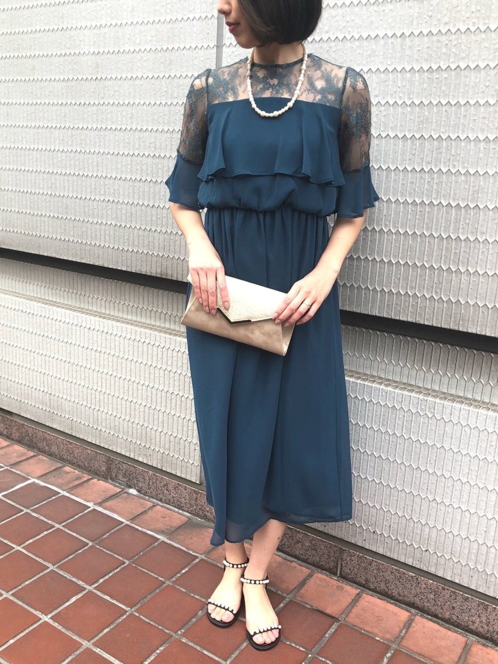 グリーン系のドレスを着用したレディースの春コーディネートの1枚目の写真