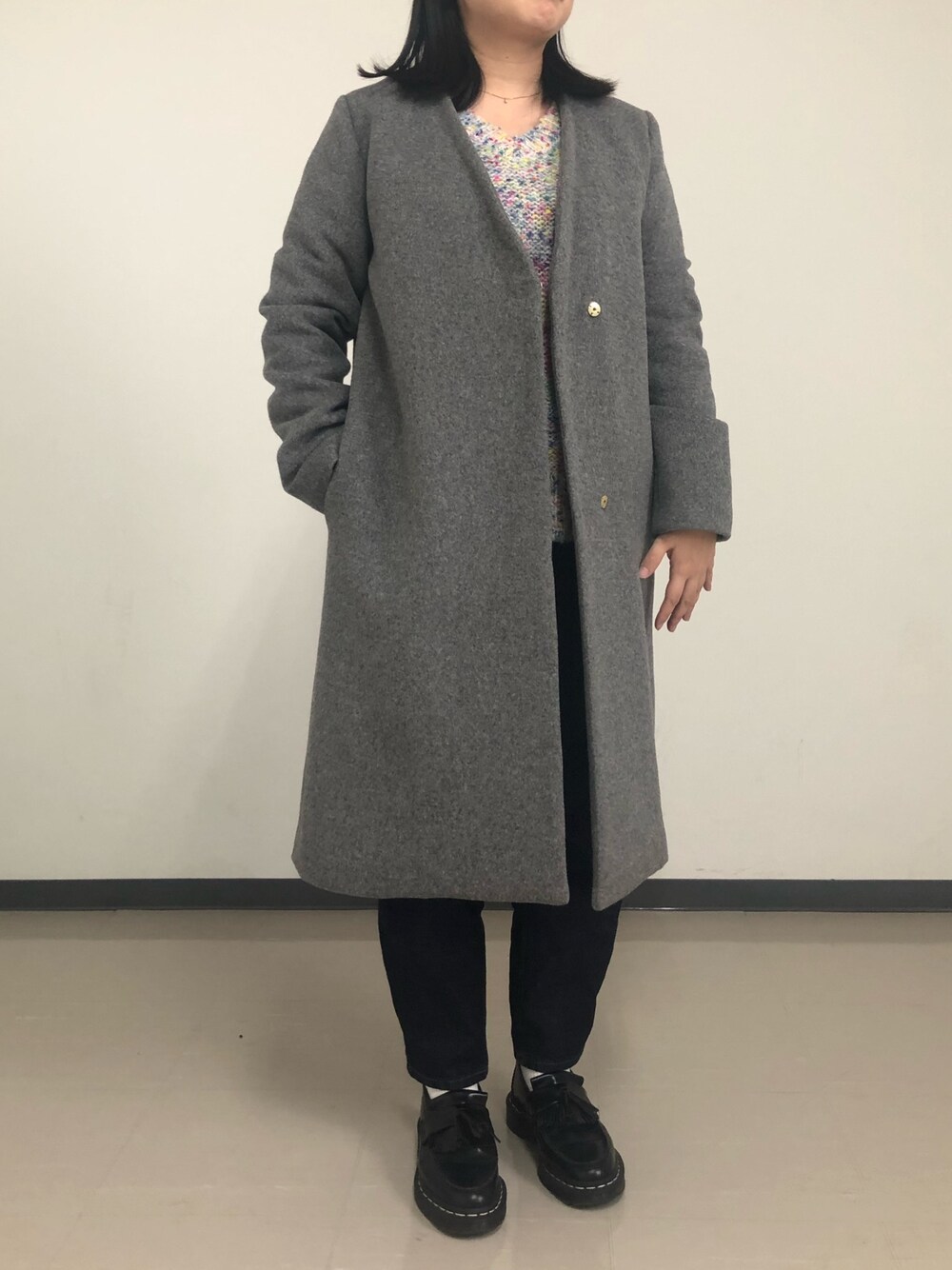 グレー系のノーカラーコートを着用したレディースの秋コーディネートの1枚目の写真