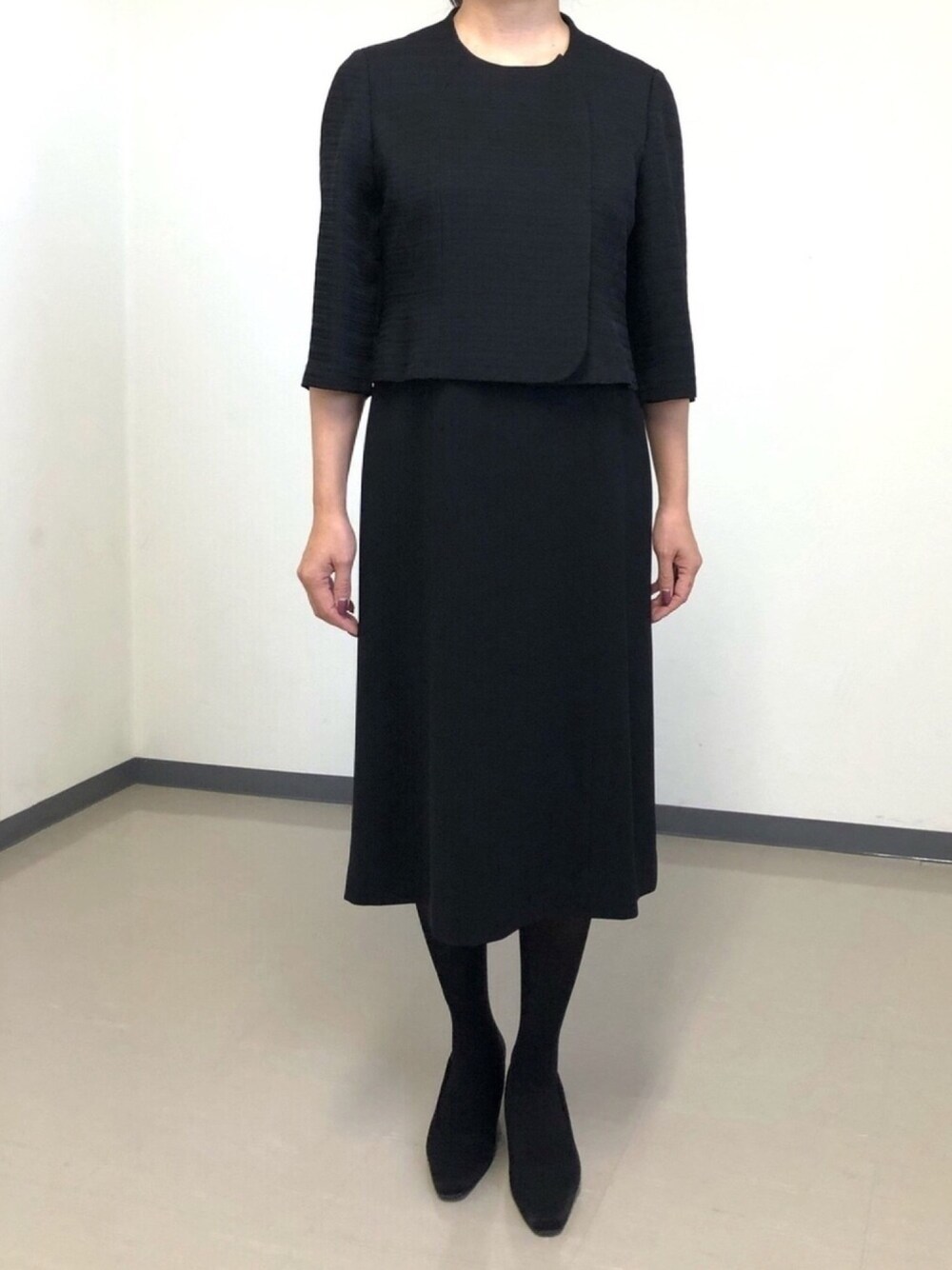 ブラック系のスーツセットを着用したレディースの秋コーディネートの1枚目の写真