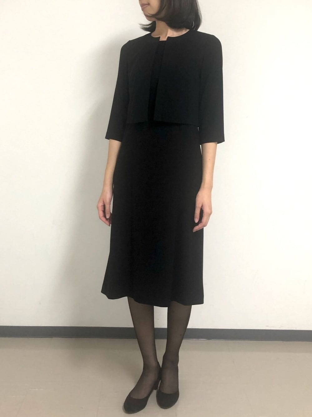 ブラック系のスーツセットを着用したレディースの冬コーディネートの1枚目の写真