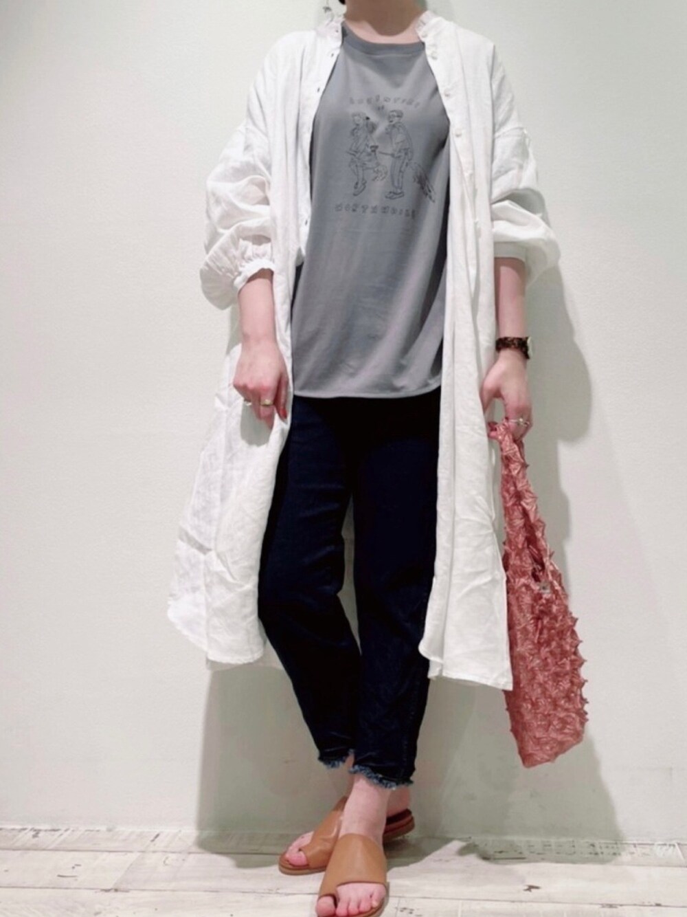 ホワイト系のワンピース、グレー系のTシャツ/カットソー、ブルー系のデニムパンツを着用したレディースの春コーディネートの1枚目の写真