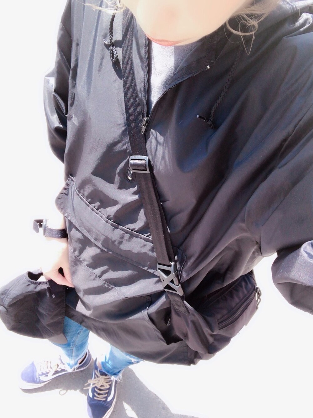 ブラック系のボディバッグ/ウエストポーチ、ブルー系のスニーカー、ブラック系のTシャツ/カットソーを着用したレディースの春コーディネートの1枚目の写真